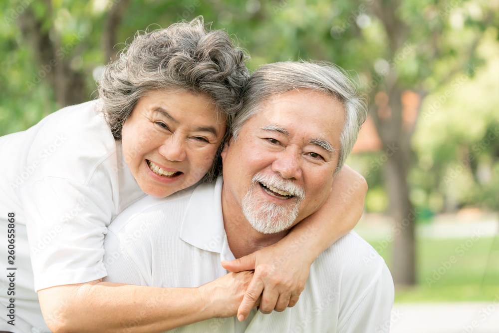 Happy love Elderly couple smile face , Senior couple old man and senior woman relaxing hug in a forest Happy love Elderly couple smile face , Senior couple old man and senior woman relaxing hug in a forest