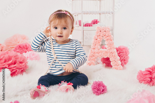 top view: the girl child mother sitting on the floor among the numbers 1, artificial flowers and a bird cage photo