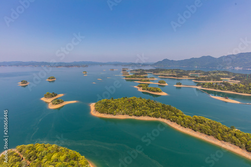 Aerial photography of "mini-island" in Lushan Sea, inlaid with blue water, is like "Jadeite falling jade plate". Natural scenery background. © HAIYAN