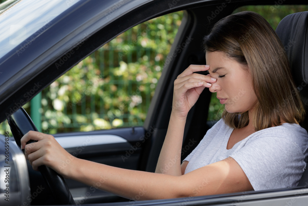 female driver with headache in a car