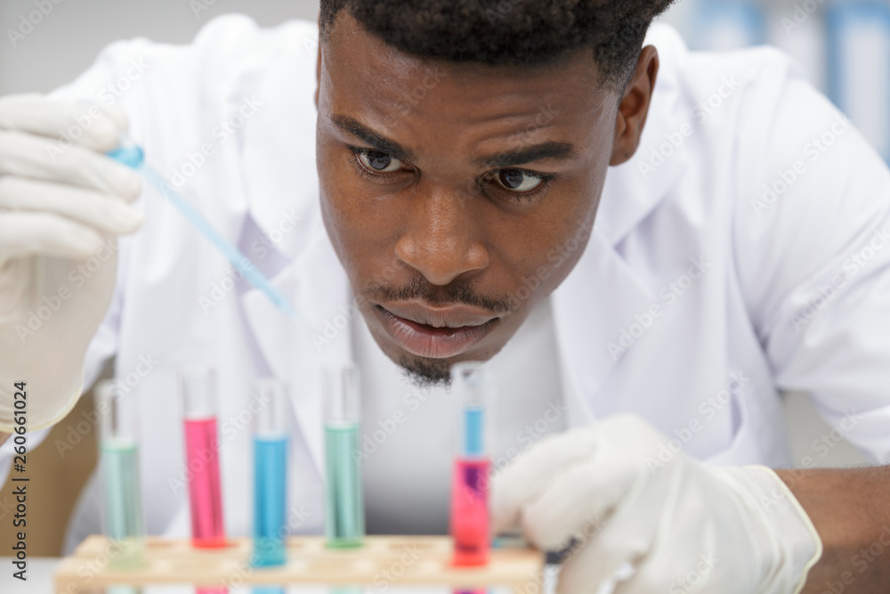 scientist dripping reagent into test tubes scientist dripping reagent into test tubes
