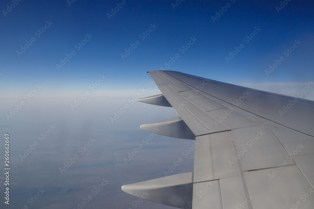 Wing of an airplane flying above the morning clouds Wing of an airplane flying above the morning clouds