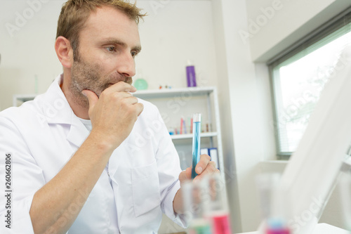 man holds liquids in the lab