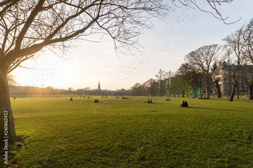 EDINBURGH, SCOTLAND, 20 February 2019, People watching sunset sitting on the green grass near university