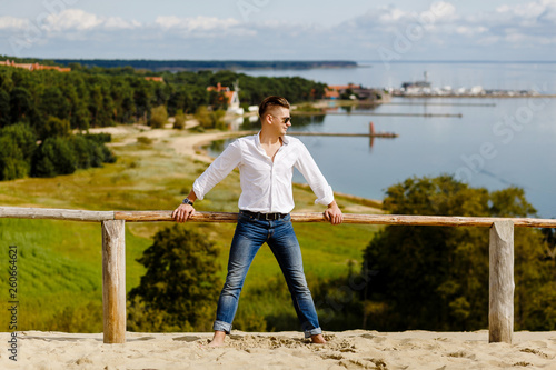 Portrait of a stylish guy on the slope against the backdrop of the sea © Vladimir