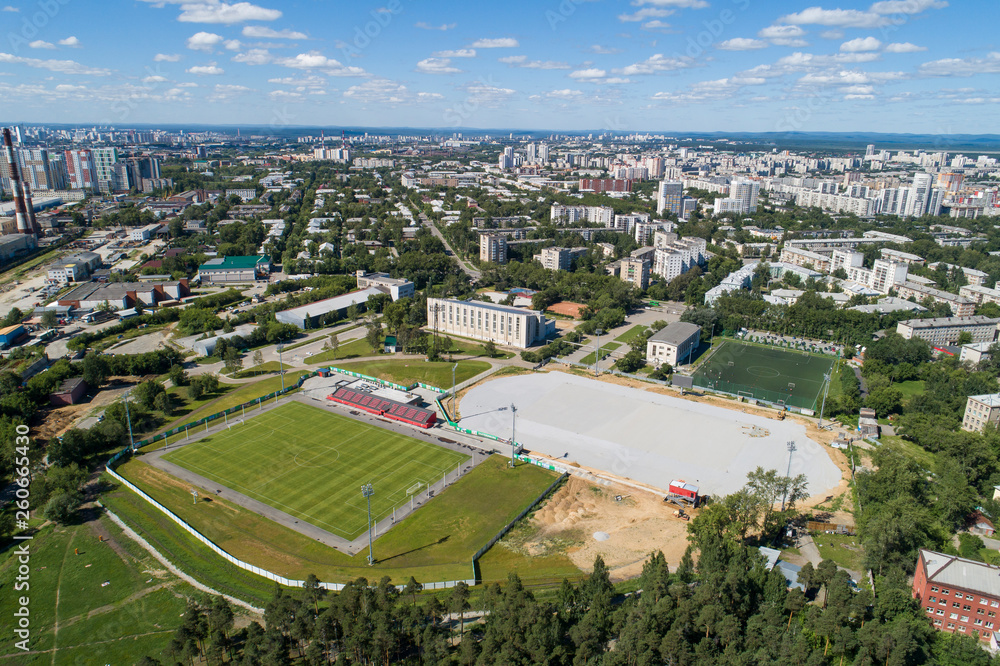 Top down aerial drone image of a Ekaterinburg with stadiums: ready and under construction. Midst of summer, backyard turf grass and trees lush green.