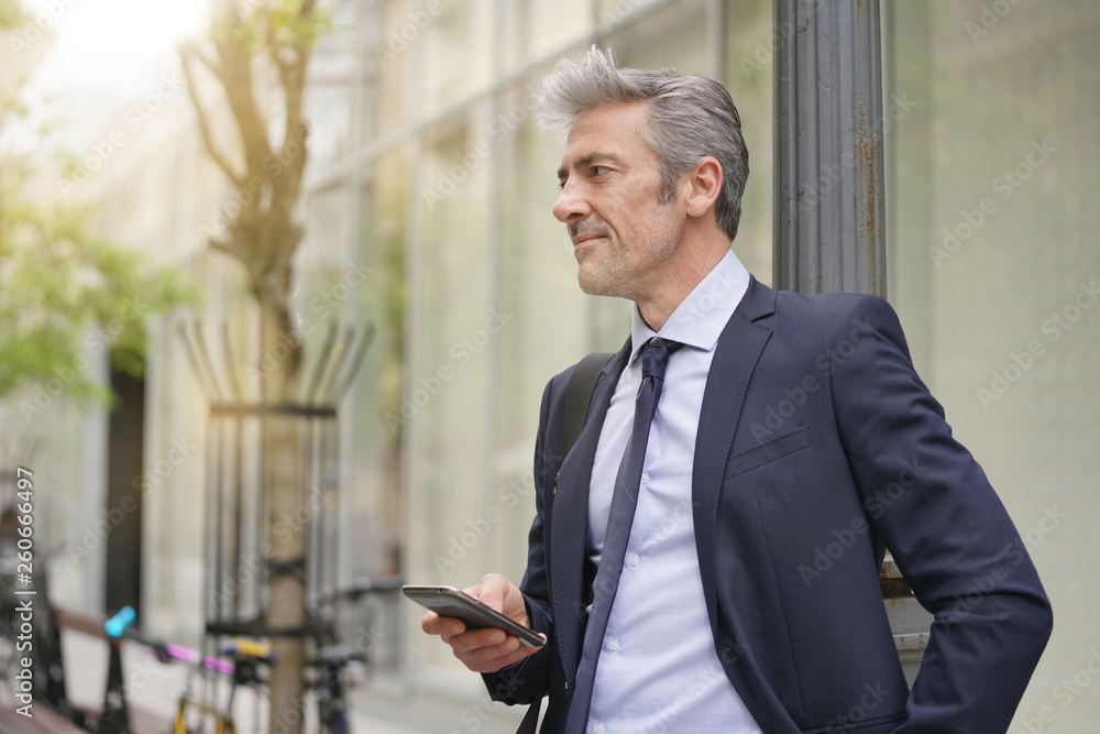 Businessman commuting on foot with cellphone Businessman commuting on foot with cellphone