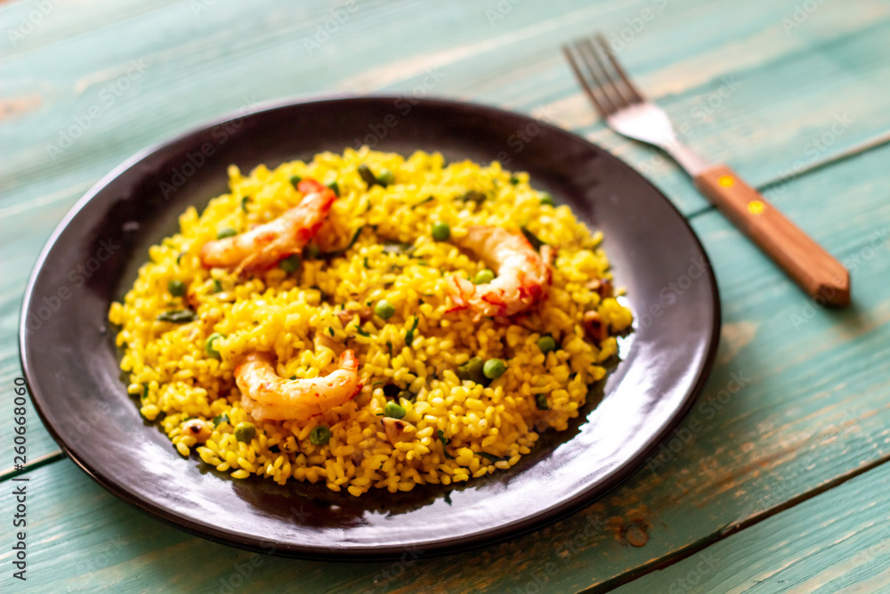 Paella with shrimp on a blue wooden background Paella with shrimp on a blue wooden background
