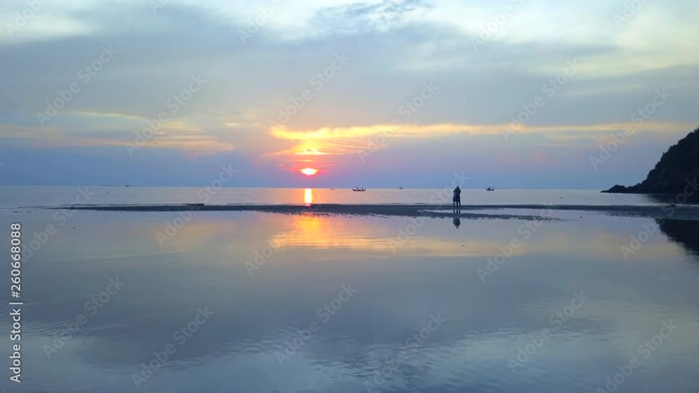 The couple looks at the sunset on the sea, cam slowly approaching The couple looks at the sunset on the sea, cam slowly approaching