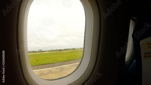 POV of passenger plane takes off from airfield and flies under big city view from porthole