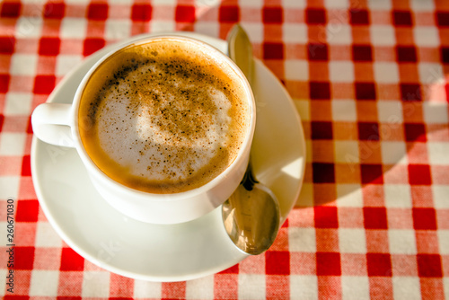 A Cup of cappuccino is on the table in the cafe 