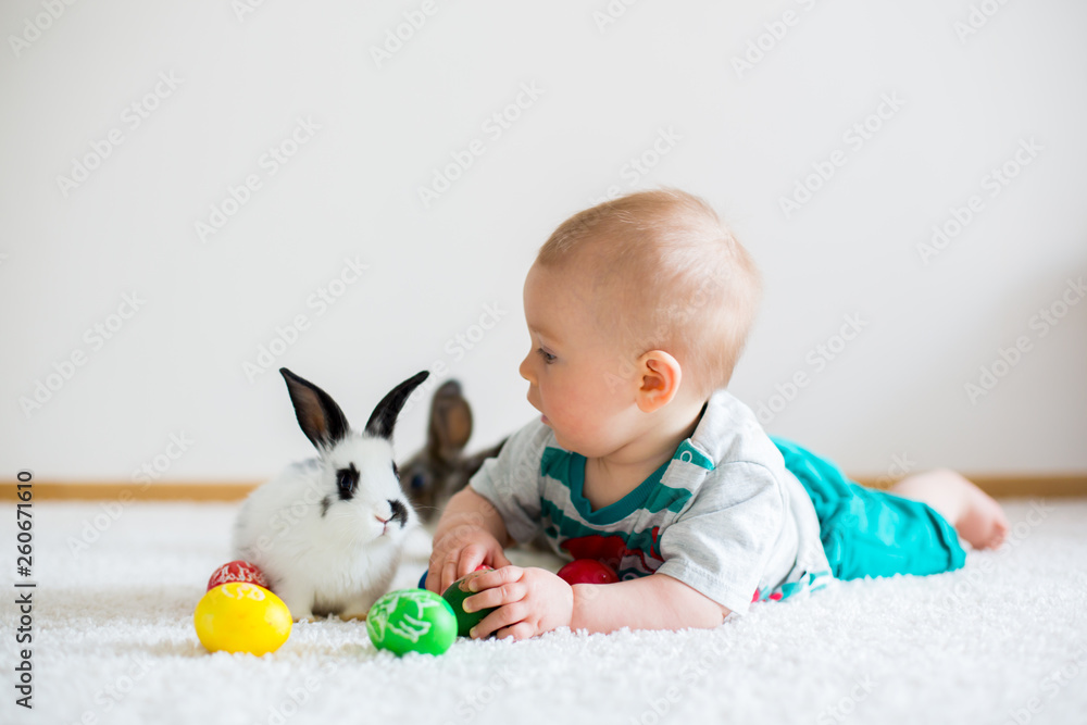 Little toddler child, baby boy, playing with bunnies and easter eggs at home Little toddler child, baby boy, playing with bunnies and easter eggs at home