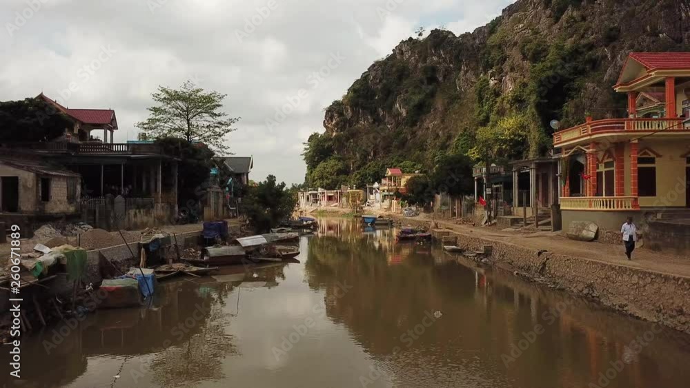 Pull-back over a of a muddy river running through a Vietnamese town Pull-back over a of a muddy river running through a Vietnamese town