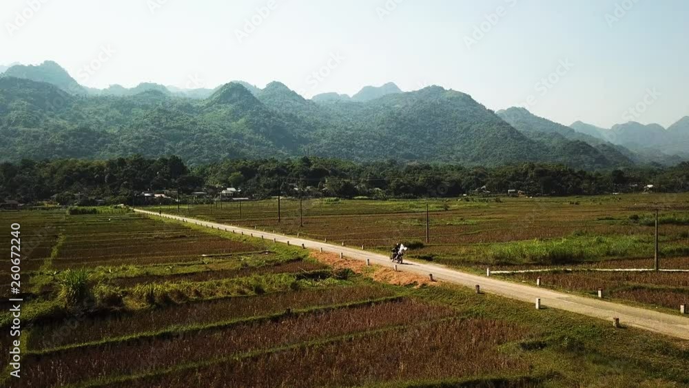 Motorcycle gang heading down country road in Hanoi, Vietnam, towards mysterious mountains Motorcycle gang heading down country road in Hanoi, Vietnam, towards mysterious mountains