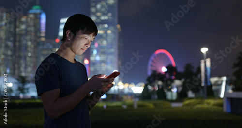 Young man use of mobile phone in city at night