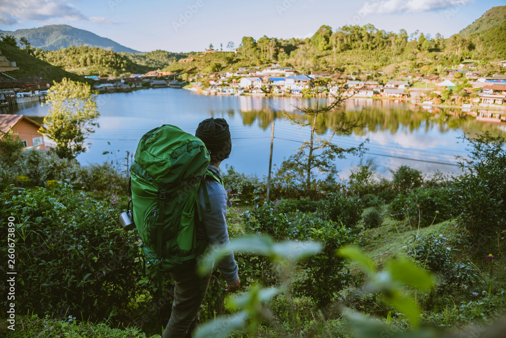 Fototapeta premium Asian man travel nature. Travel relax, Camping in a rural village on the mountain, near the lake.