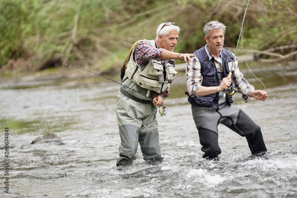 © goodluz - Fly fishing expert guiding novice in river © goodluz - Fly fishing expert guiding novice in river