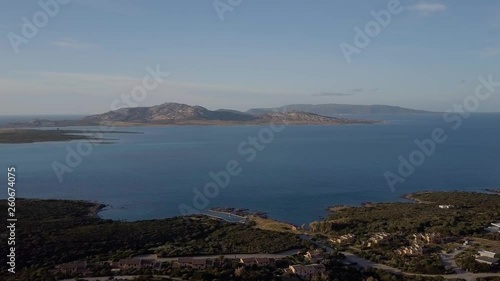 Aerial of a pretty village in Sardinia, Italy. Sunrise on the coast, mountains in the background photo