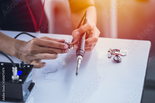 electornic engineer using soldering iron to making small circuit robot hardware.