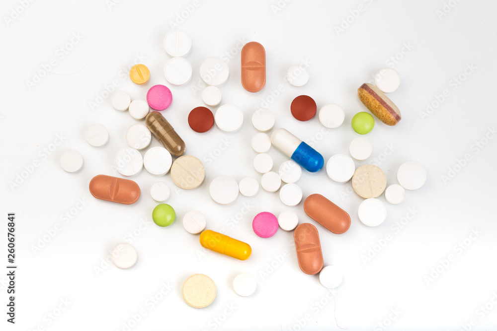 set of multi-colored tablets and capsules on a white background