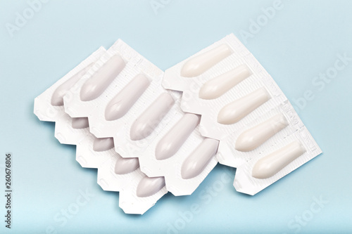 plastic packs of suppositories on blue  background