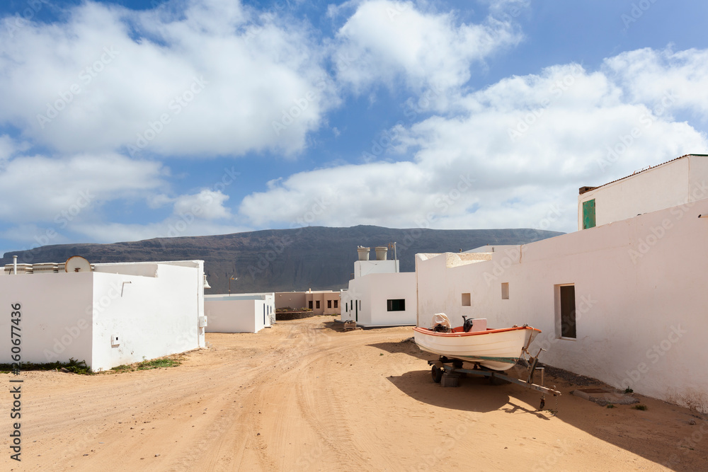Empty street with sand and white houses in Caleta de Sebo on the island La Graciosa Empty street with sand and white houses in Caleta de Sebo on the island La Graciosa