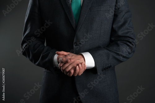 Businessman with a crossed arms on a gray background. Business acumen. Strict boss.