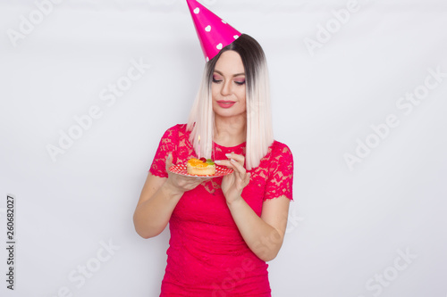 Blond in party hat holding cake