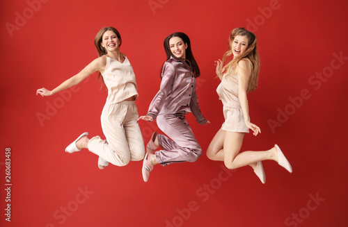 Beautiful jumping women on color background