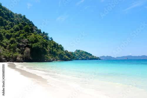 Fototapeta Naklejka Na Ścianę i Meble -  Tropical sand beach island and crystal clear sea water in sunny day. Vacation and holiday in paradise island.