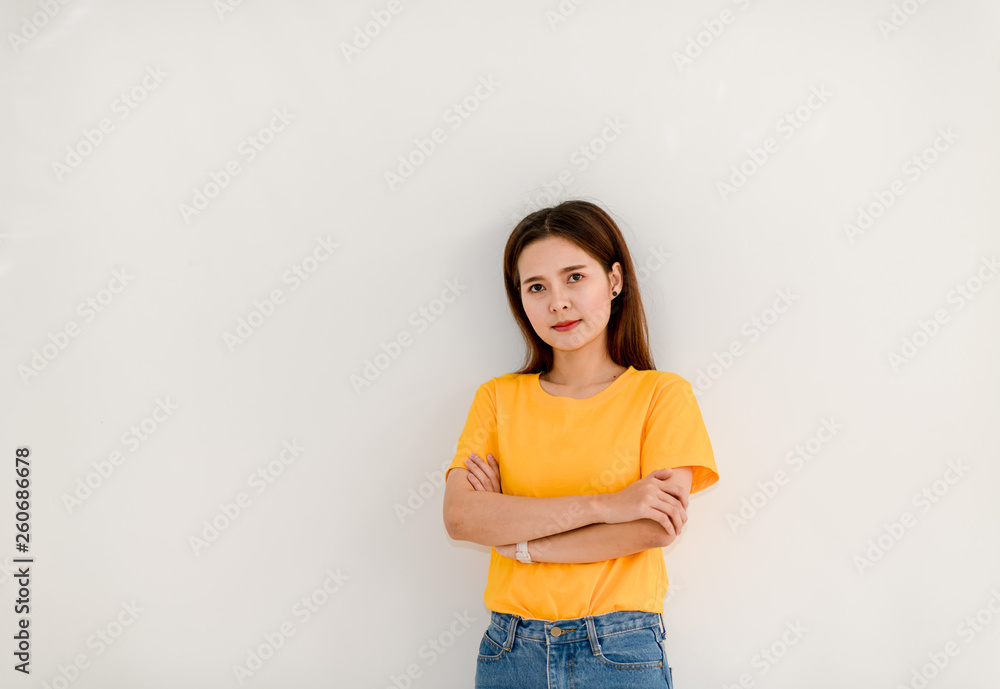 Beautiful Asian woman confident in a yellow sweater and jeans on a white background. Beautiful Asian woman confident in a yellow sweater and jeans on a white background.