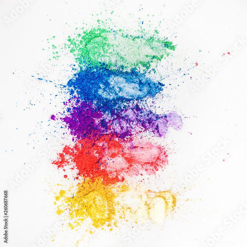 Bright eye shadows in different colors of the rainbow  scattered on a white background.