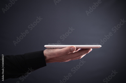 Hand holding white digital tablet. Concept of new technology