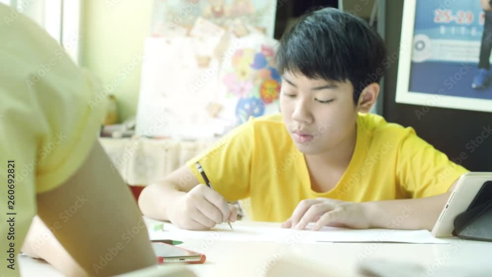 Child writes homework. Children to doing home works on table in living room