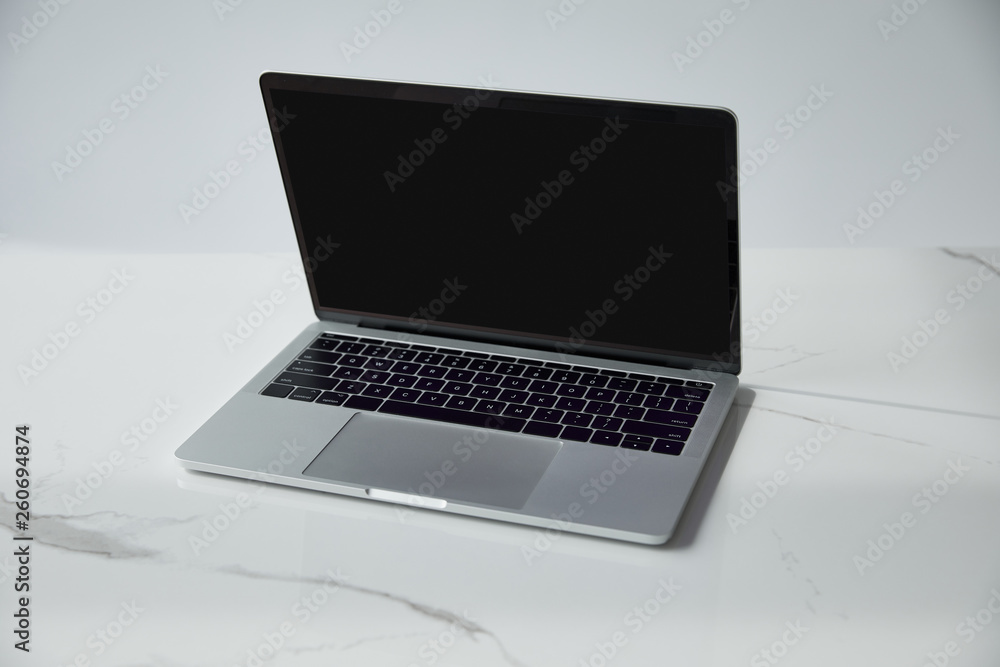 laptop with blank screen and black keyboard on white marble surface isolated on grey
