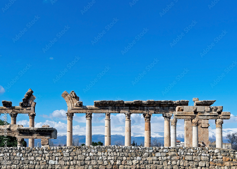 Fototapeta premium Corinthian Capitals outside Baalbek temple complex with snowy mountain range as a backdrop, Lebanon