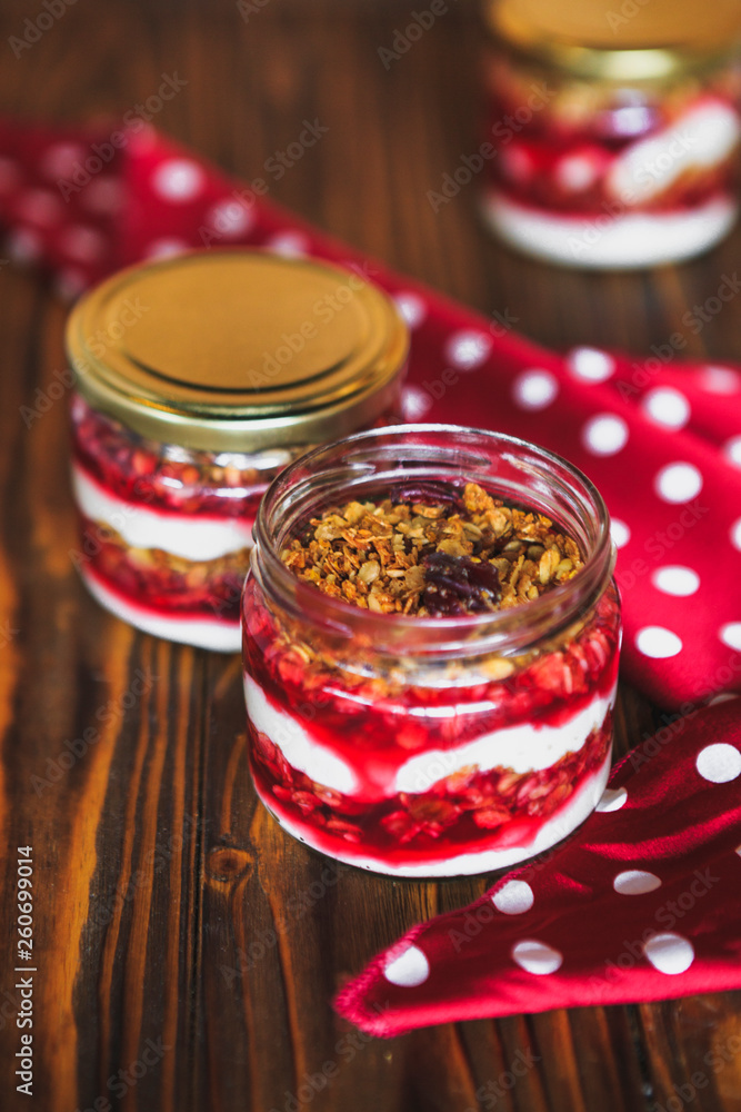 Summer fruit red berry breakfast. Healthy cherry split breakfast with cream cheese, granola, nuts and dried fruits white chocolate. In mason jar, on table. Copy space Summer fruit red berry breakfast. Healthy cherry split breakfast with cream cheese, granola, nuts and dried fruits white chocolate. In mason jar, on table. Copy space