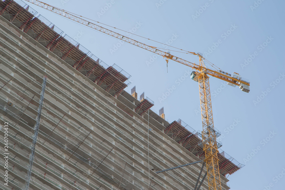 A crane in a construction work. Building crane. Lifting crane build multi-storey building