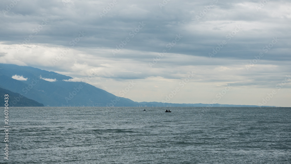 Fishermen in the sea on a small boat on a cloudy day