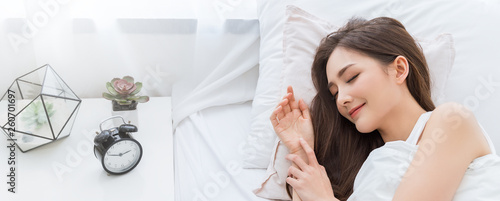 Portrait of beautiful young sexy asian woman smile enjoy fresh soft bedding linen and mattress in bed room modern apartment. Teenage girl resting, good night sleep concept panoramic banner