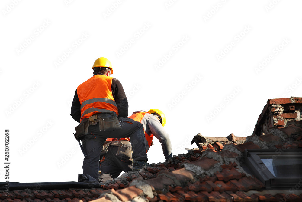 Two builders in working clothes fixing an old tiled roof on a building. Construction work at height on an isolated white background for further design. Safety equipment high-altitude professions Two builders in working clothes fixing an old tiled roof on a building. Construction work at height on an isolated white background for further design. Safety equipment high-altitude professions