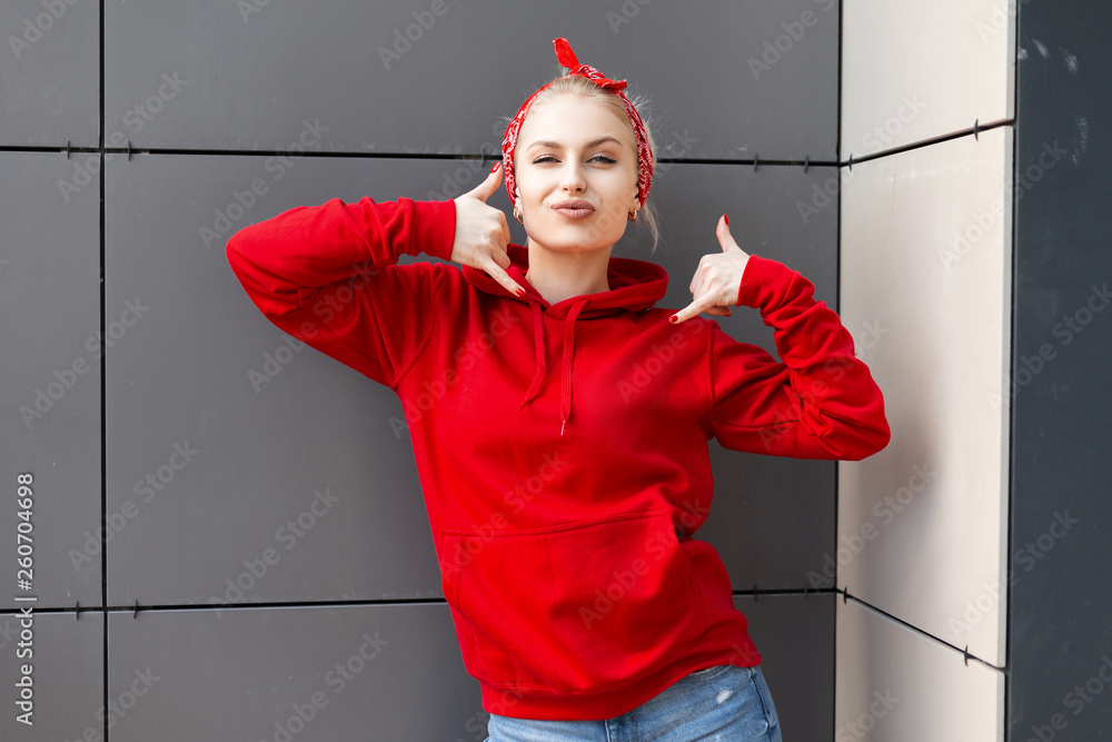 Funny cute young woman in vintage red sweatshirt with a hood with