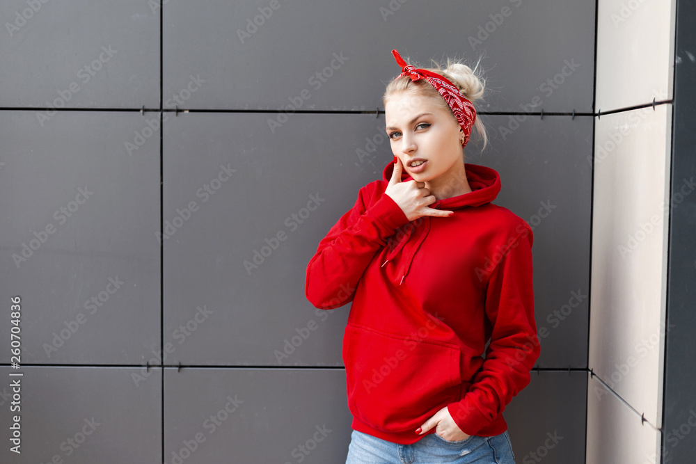 Sensual sexy young blonde woman in a vintage bandana in a red stylish  sweatshirt in blue
