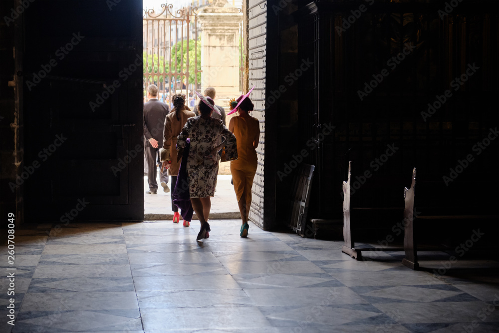 elegant traditional woman dress - peoples exiting from a church after ceremony - Seville Spain.