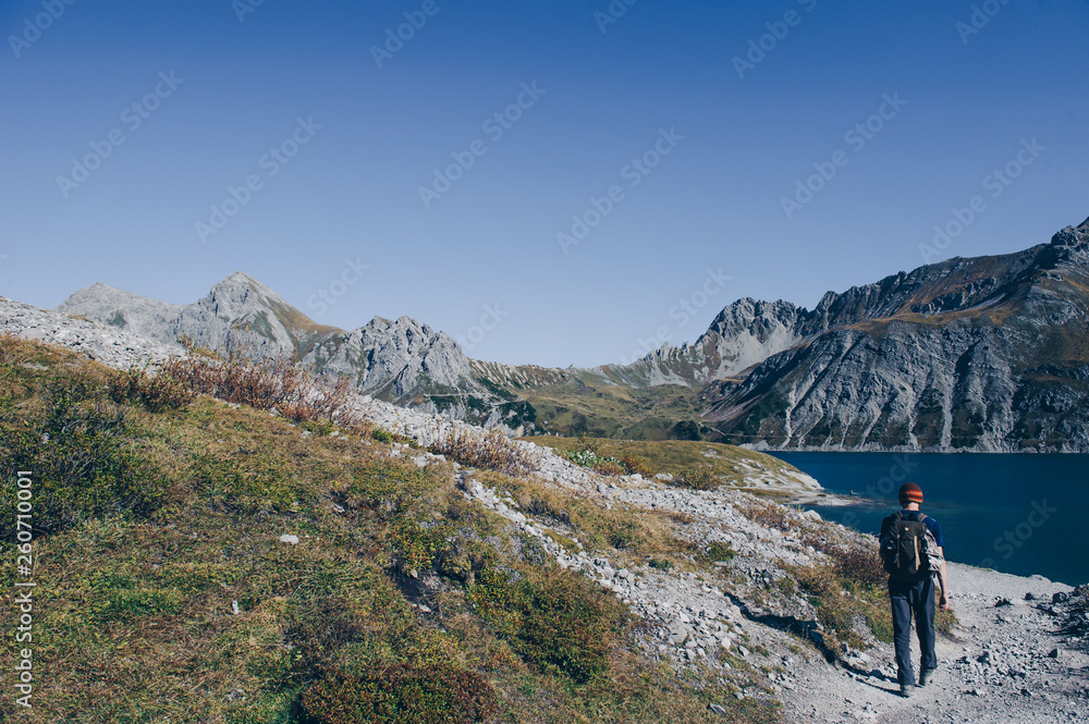 Wanderer mitten in der Bergen an einem Bergsee im Rätikon.