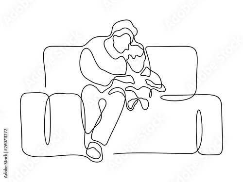 Dad and his little son sitting on a sofa and reading a book together