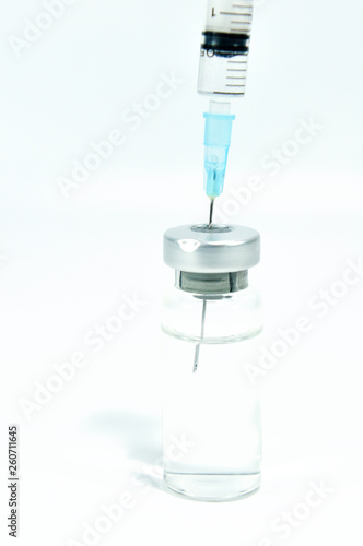 syringe needle in vial with vaccine