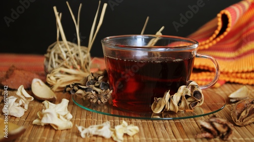 Tea cup with tea leaves. cozy autumn or winter morning at home. Still life details with cup of tea, sketch book with herbarium