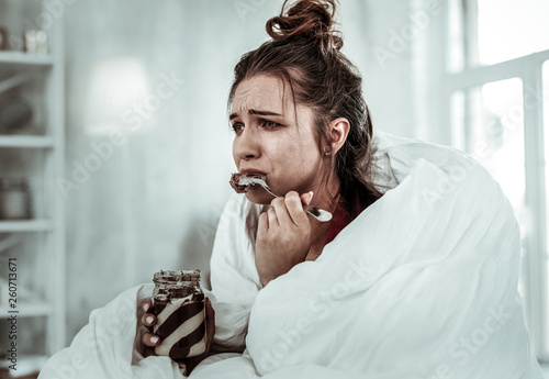Woman eating chocolate pasta because of being stressed