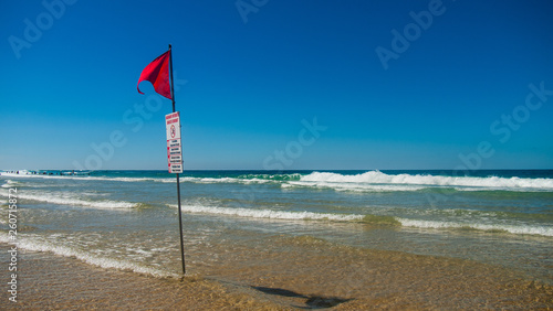 bandiera rossa su una spiaggia oceanica